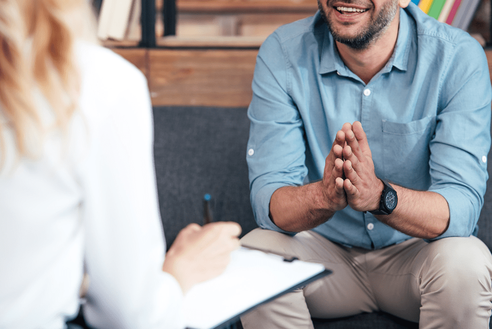 a man with hands together in therapy