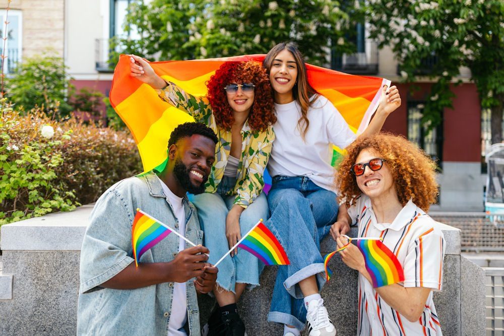 Diverse friends celebrating LGBTQ Pride Month with rainbow flags outdoors